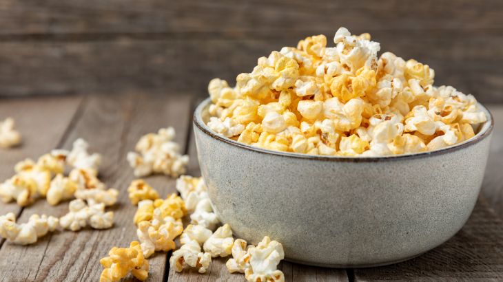 Tasty popcorn on wooden background. Cinema and entertainment concept. Movie night with popcorn.Cheese and caramel popcorn. Delicious appetizer, snack. Place for text. Copy space.Banner